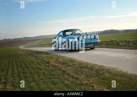 blue Porsche 911 Carrera at speed on tarmac country road International Horneland Rally Netherlands Stock Photo