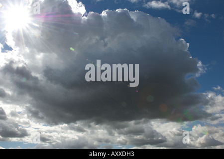 Large Cloud and Blue Sky and Sun Flare Stock Photo