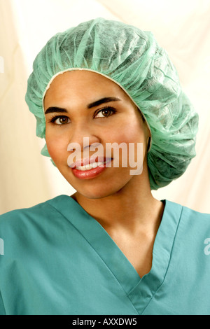 Female healthcare personnel wears green scrubs and matching hairnet. Stock Photo