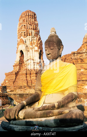 Sitting Buddha statue and chedi (pagoda) (stupa) at Buddhist temple of Wat Phra Mahathat, Ayuthaya, Thailand Stock Photo
