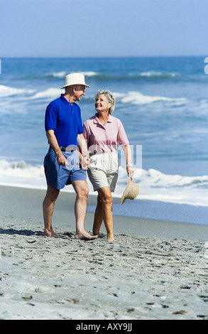 Seniors relaxing together, walking on beach, Miami Stock Photo