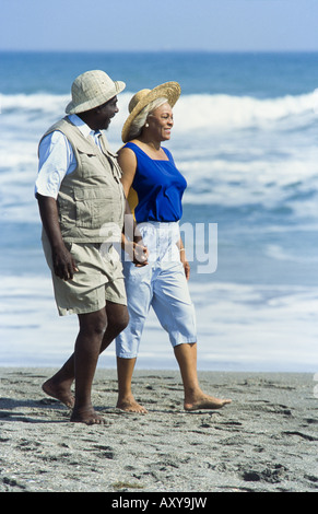 Seniors relaxing together, walking on beach, Miami Stock Photo
