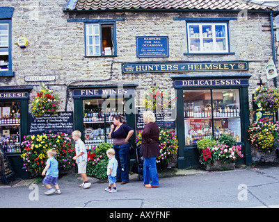 HELMSLEY NORTH YORKSHIRE UK September A  speciality shop in Market Square with two women and three children walking past Stock Photo