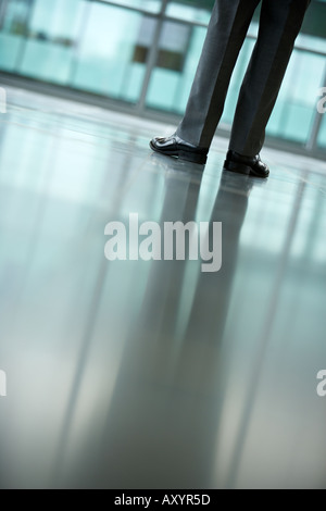 Businessman s legs and feet in an empty office Stock Photo
