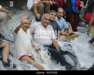 Men cooling off at a waterfall of a river in the rainy season (Monsoon), India, Maharashtra, Kandala Stock Photo