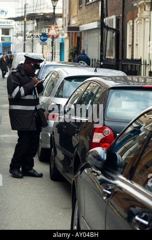 Traffic Warden issuing parking ticket in London Street Stock Photo