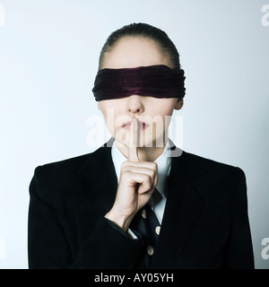 studio shot portrait of a beautiful young blindfold woman in a costume suit Stock Photo