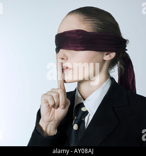 studio shot portrait of a beautiful young blindfold woman in a costume suit Stock Photo