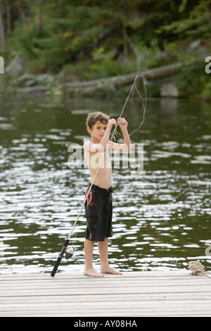 Kids hobby. Smiling child fishing on the lake. Boy with spinner at river.  Portrait of excited boy fishing. Boy at jetty with rod Stock Photo - Alamy