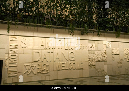 Sculptured sandstone art wall display, behind the Green Wall in the Arrivals Hall at Terminal 3, Changi Airport, Singapore Stock Photo