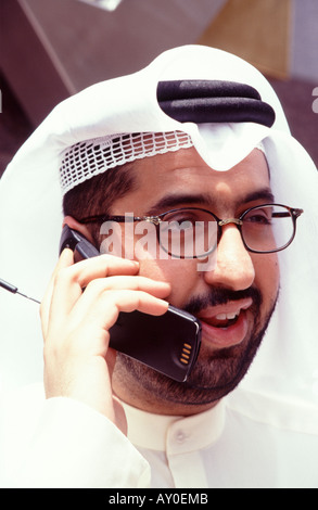 kuwaiti businessman talking happily on a mobile phone in the kuwait stock exchange kuwait city middle east arabian gulf Stock Photo