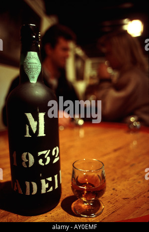 young couple tasting madeiran wine in funchal madeira with the bottle in focus in the foreground Stock Photo