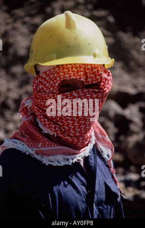 saudi arabian construction worker wearing protective clothing hiding body and face from the nidday heat and sun in jeddah saudi Stock Photo