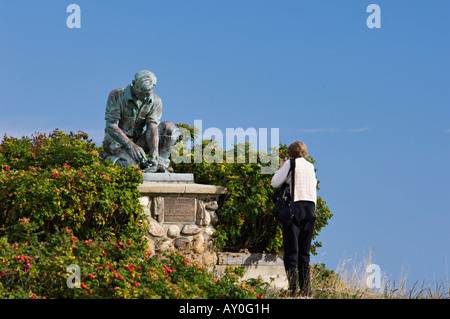 Woman taking Photo of Bronze Statue Memorializing Maine Fishermen Bailey Island Maine Stock Photo