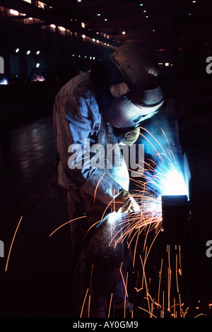 Welder at work at a sea container building factory in shanghai china fareast asia showing glow and sparks Stock Photo