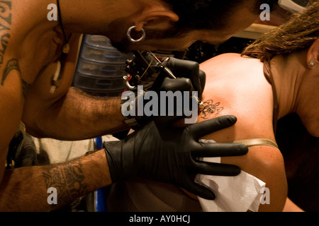 Tattoo artist on Easter Island working on a tribal tattoo for a tourist Stock Photo