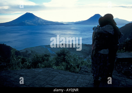 Couple embracing while overlooking Lake Atitlan at dusk, Guatemala Stock Photo