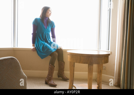 Young woman sitting in hotel room Stock Photo