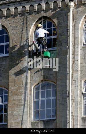 Window cleaners working on the windows of Abbey Mill recently converted to retirement flats in Bradford on Avon Wiltshire Stock Photo