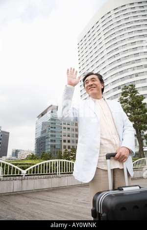 Mature man waving hand Stock Photo