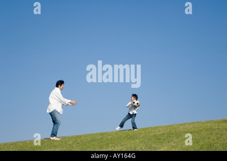 Father and son playing with soccer ball Stock Photo