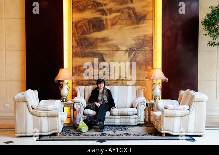 Woman tourist waiting in lobby of Anting Villa Hotel, Shanghai. This is a hotel in the French Concession area of Shanghai, China Stock Photo
