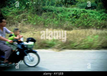 Thailand Chiang Mai Province, Northern Thailand Chang Mai Motorcyclist with child - no helmets - driving in Chang Mai. Stock Photo