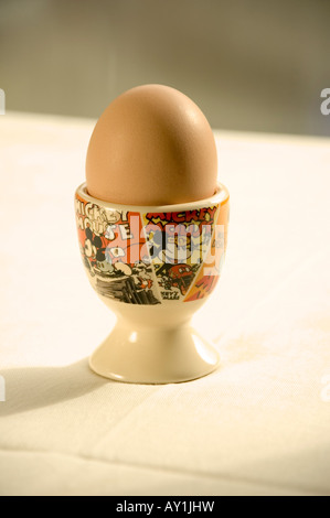 Boiled free range egg in a Walt Disney Mickey Mouse egg cup in the morning sun Stock Photo