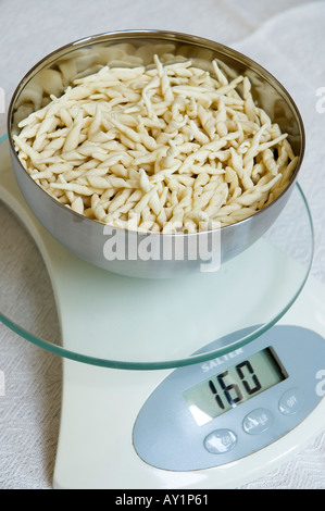 Weighing pasta to control portion sizes Stock Photo