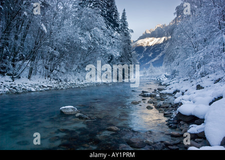 Crisp, winter scene of the flowing waters of the River Arve looking towards the Aigulle Du Midi in Chamonix, France Stock Photo