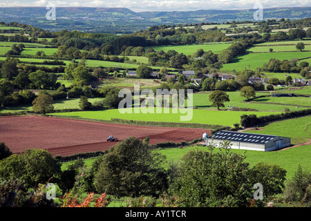 Tractor ploughing a field near a storage barn at Trellech, Monmouthshire, South Wales. Stock Photo