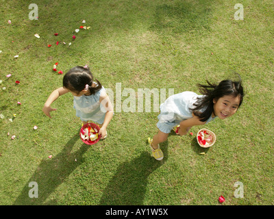 Portrait of two girls throwing rose petals in the air Stock Photo - Alamy