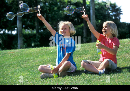 Two blond girls blowing bubbles Stock Photo