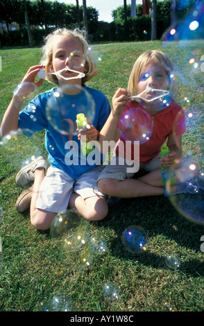 Two blond girls blowing bubbles Stock Photo