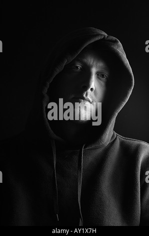 Man in a Hooded Top against a Black Background Stock Photo