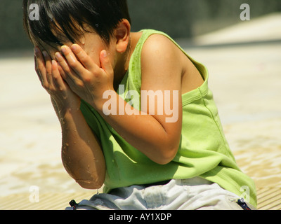 Cute boy covering his face Stock Photo - Alamy