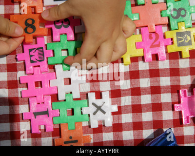 High angle view of a child's hands playing with jigsaw pieces Stock Photo
