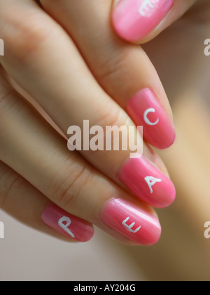 Close-up of the word peace painted on a woman's fingernails Stock Photo