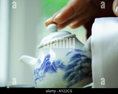 Close-up of a person's hands pouring Chinese tea into a cup Stock Photo