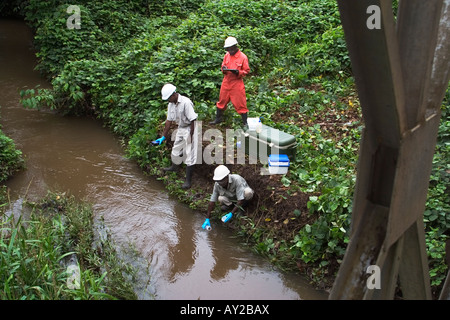 Taking water samples from river to test quality on industrial mining complex, Ghana Stock Photo