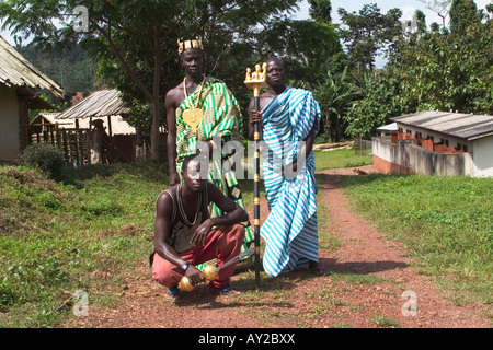 African chief in Kente cloth in his village with his linguist holding golden staff of office and his sword bearer, Ghana Stock Photo