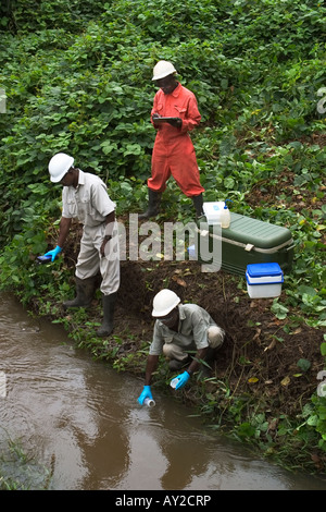 Taking water samples from river to test quality on industrial mining complex, Ghana Stock Photo