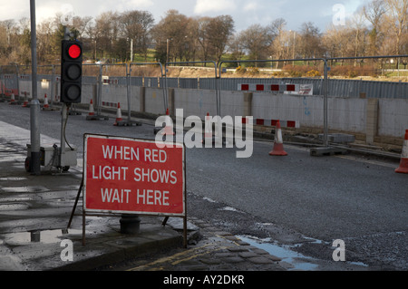 temporary traffic lights at roadworks on a road causing delays Stock Photo