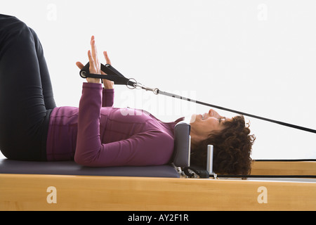 Senior woman stretching on exercise equipment Stock Photo