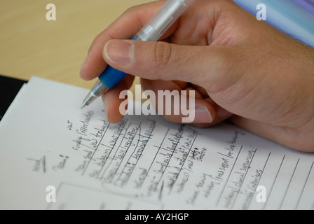 Close-up of hand taking notes at a meeting Stock Photo