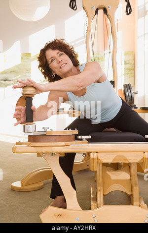 Senior woman stretching on exercise equipment Stock Photo