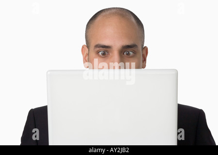 Portrait Latino man bewildered by laptop Stock Photo