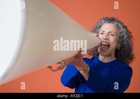 Portrait Caucasian woman yelling through megaphone Stock Photo