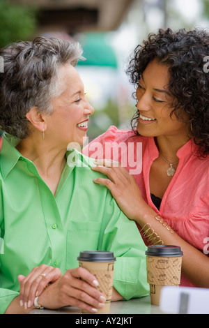 African American mother and adult daughter smiling at each other Stock Photo