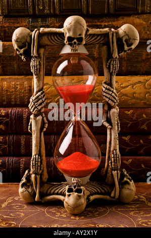 Skeleton hour glass with old antique books Stock Photo